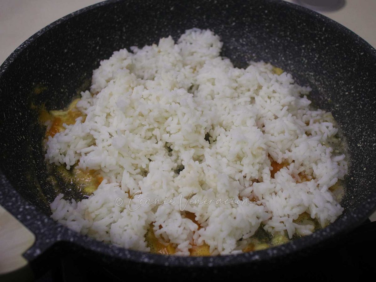 Adding rice to garlic and salted egg yolk paste