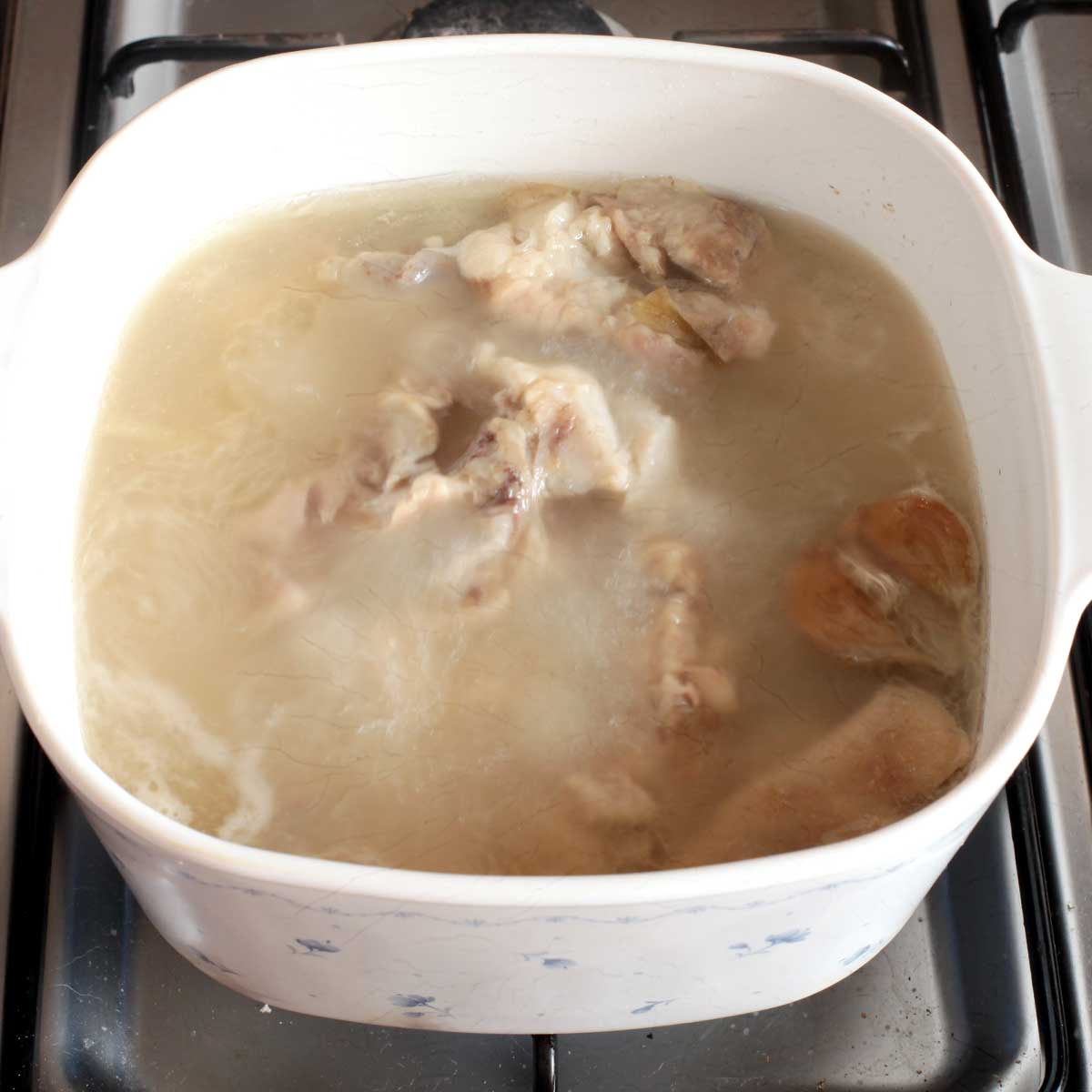 Boiling pork trotters for tonkotsu broth