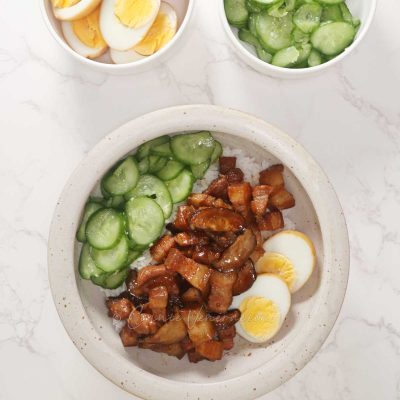 Taiwanese braised pork belly served over rice with pickled cucumber and halved egg on the side