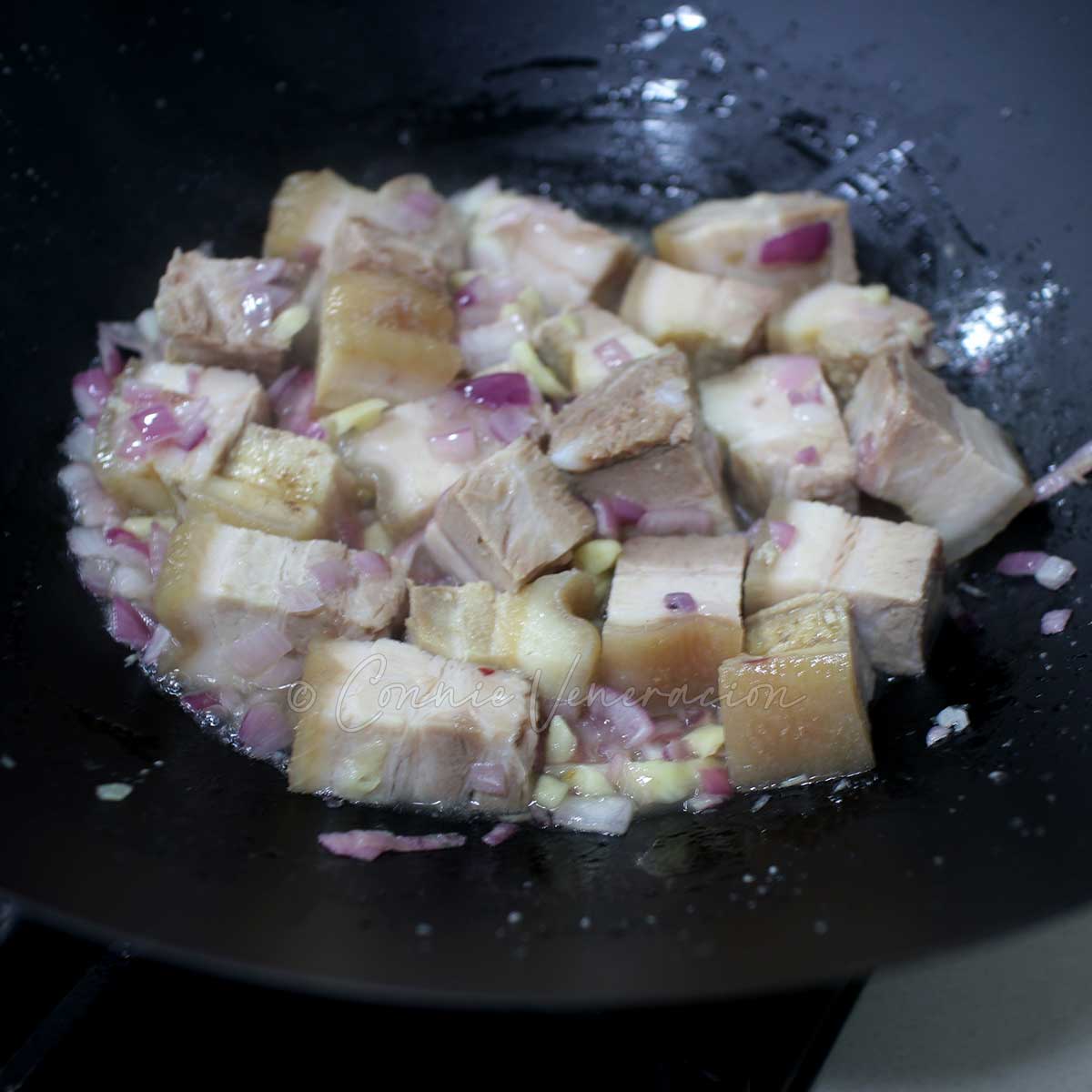 Sauteeing parboiled pork with shallots and garlic
