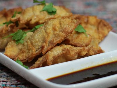 Fried dumplings on plate with dipping sauce