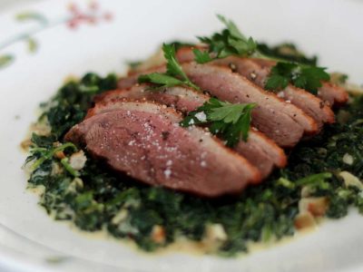 Roasted duck breast fillet served over creamed spinach