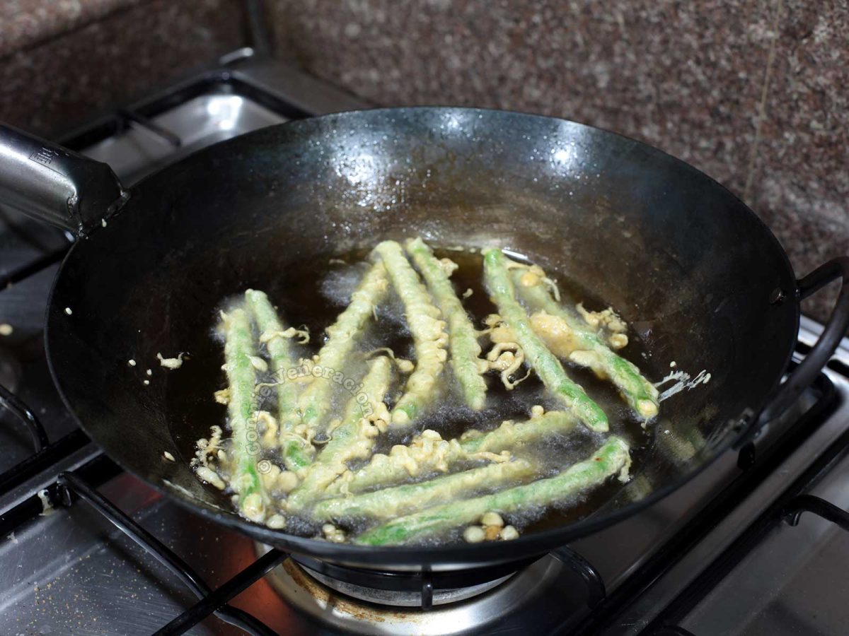 Frying green beans tempura in carbon steel wok