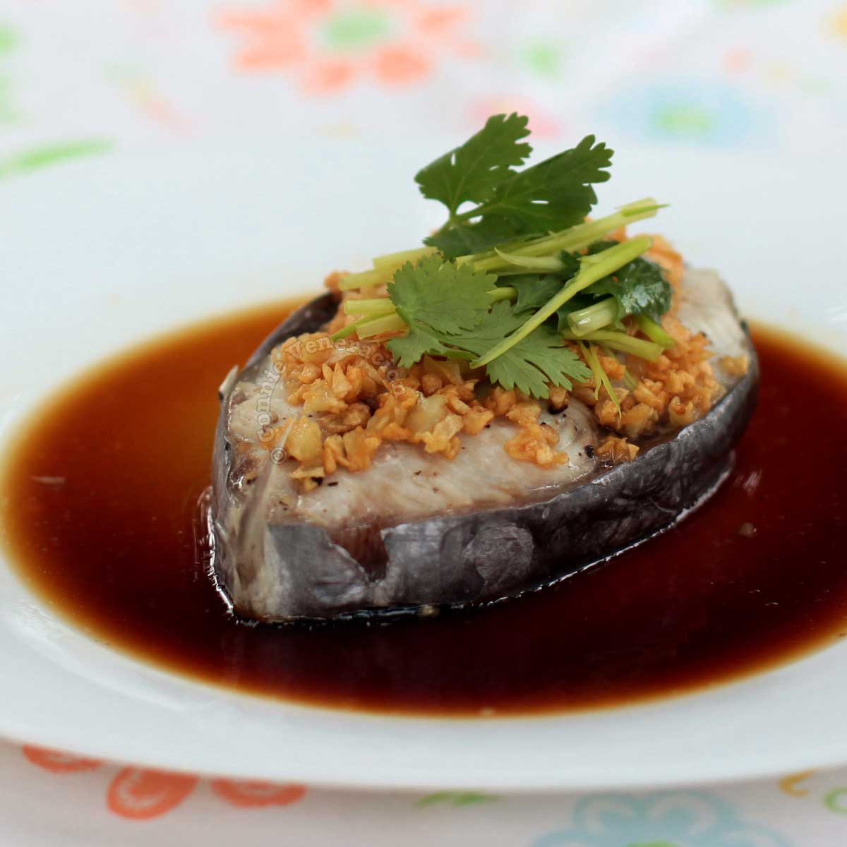 Steamed fish steak with sweet soy sauce topped with cilantro and scallions