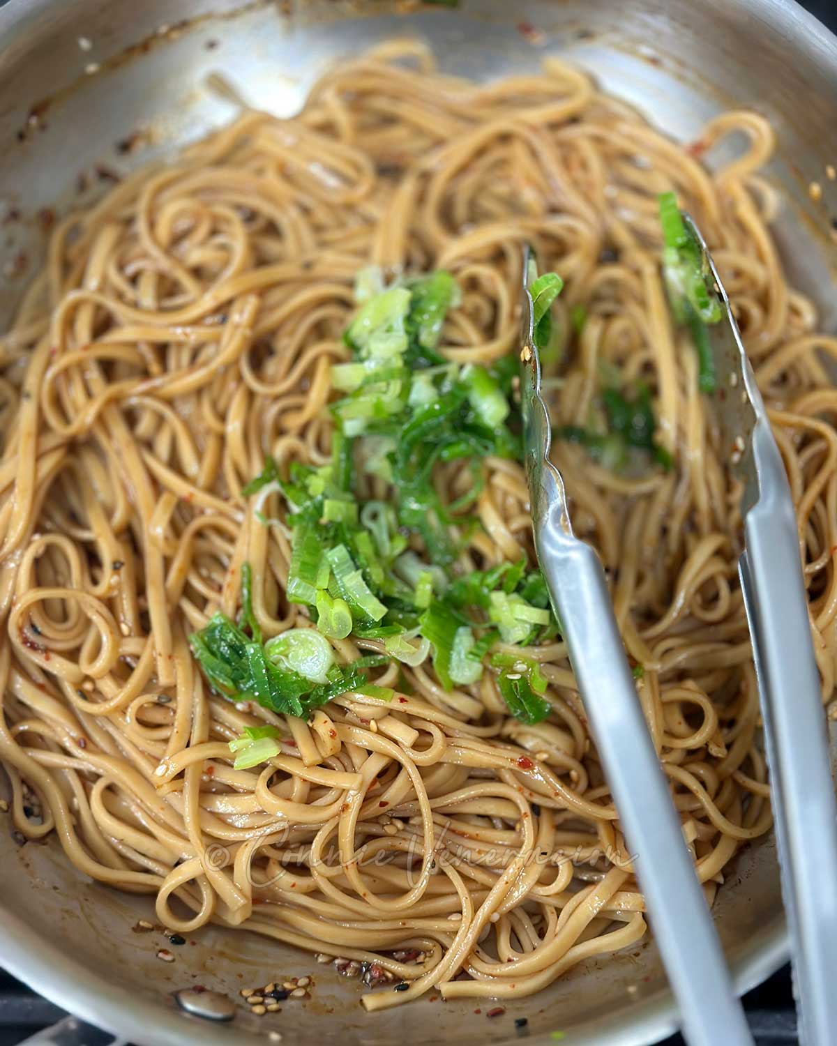 Adding fried scallions to soy sesame noodles