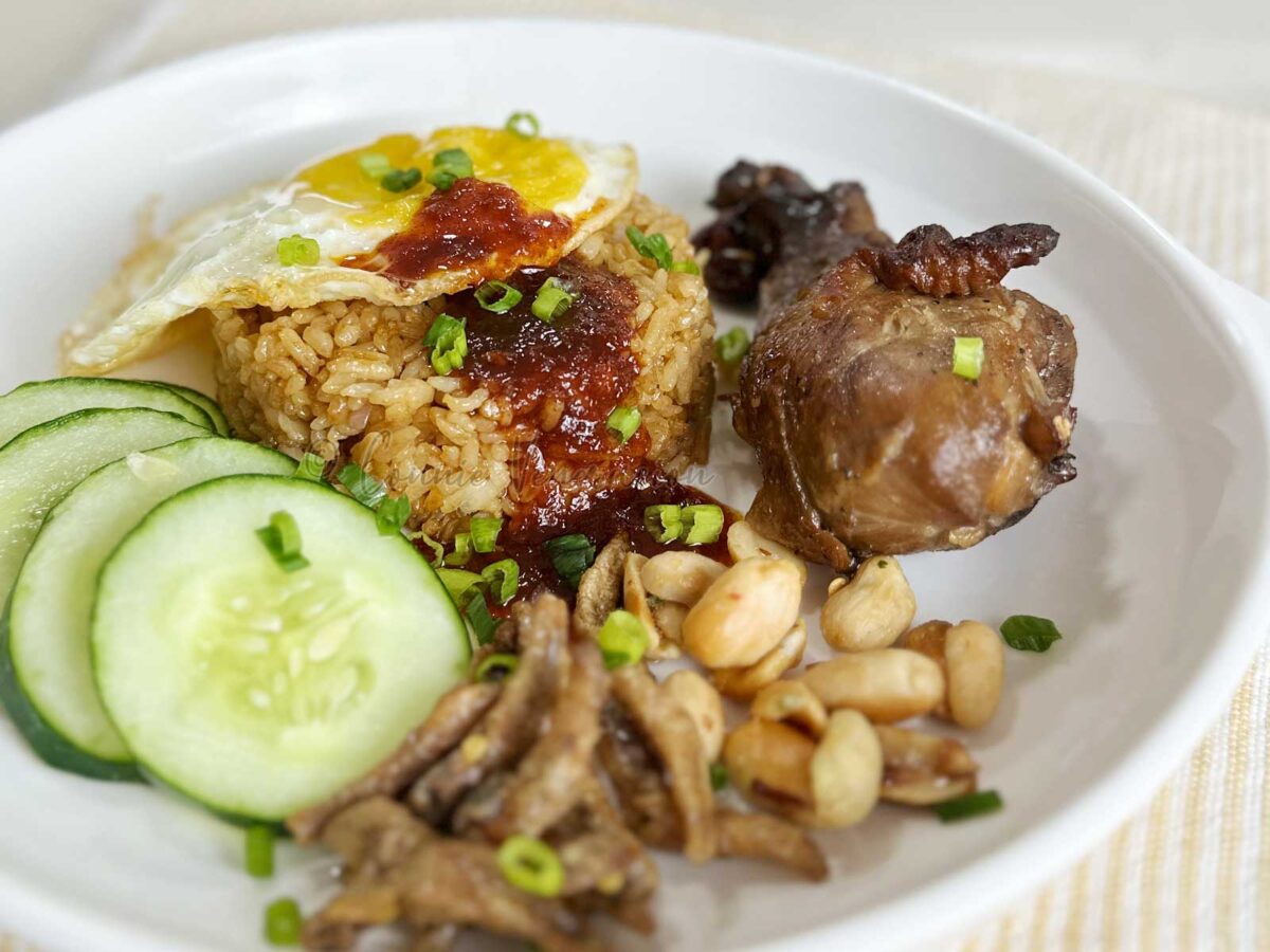 Nasi goreng (Indonesian fried rice) with egg, chicken, ikan bilis, peanuts and cucumber