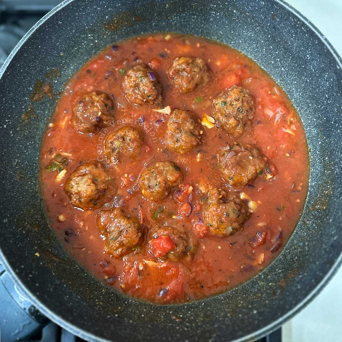 Meatballs simmering in tomato sauce
