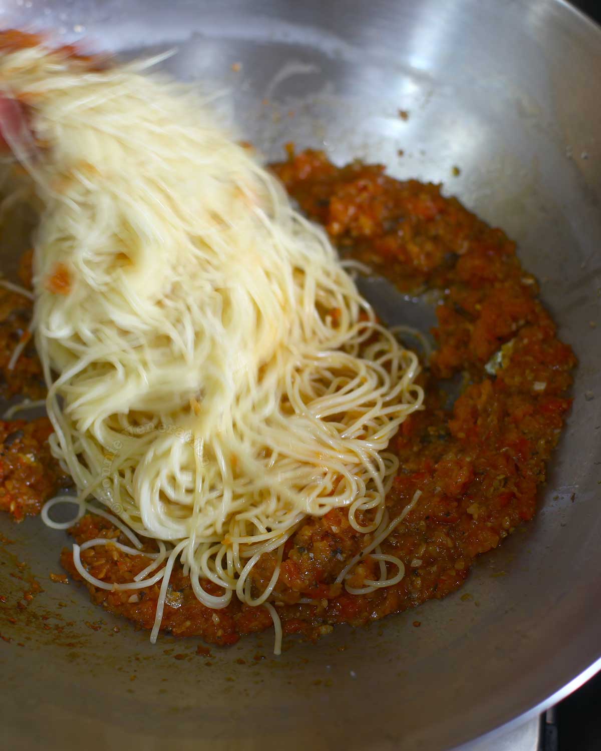 Adding cooked pasta to sauce
