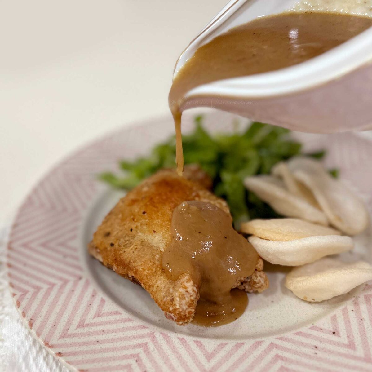 Pouring gravy over fried chicken