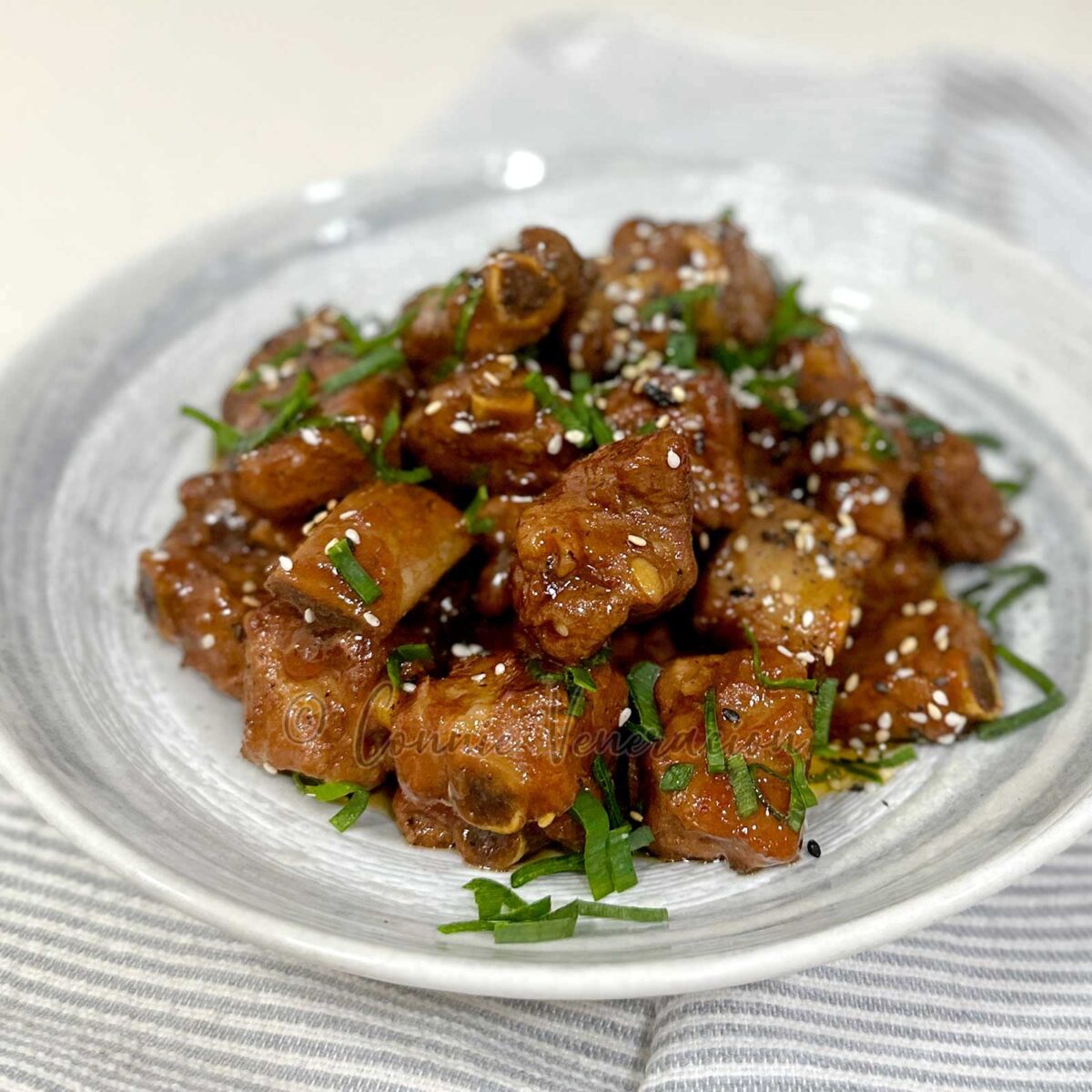 Stovetop soda braised pork ribs garnished with scallions and sesame seeds