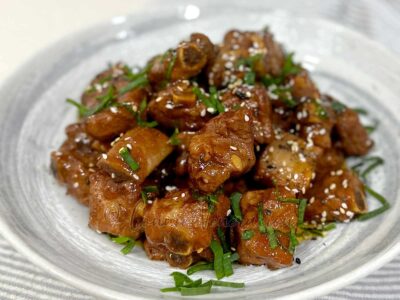 Stovetop soda braised pork ribs garnished with scallions and sesame seeds
