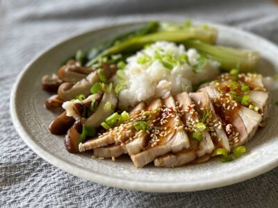 Sliced boiled pork, bok choy, shiitake and rice on a plate
