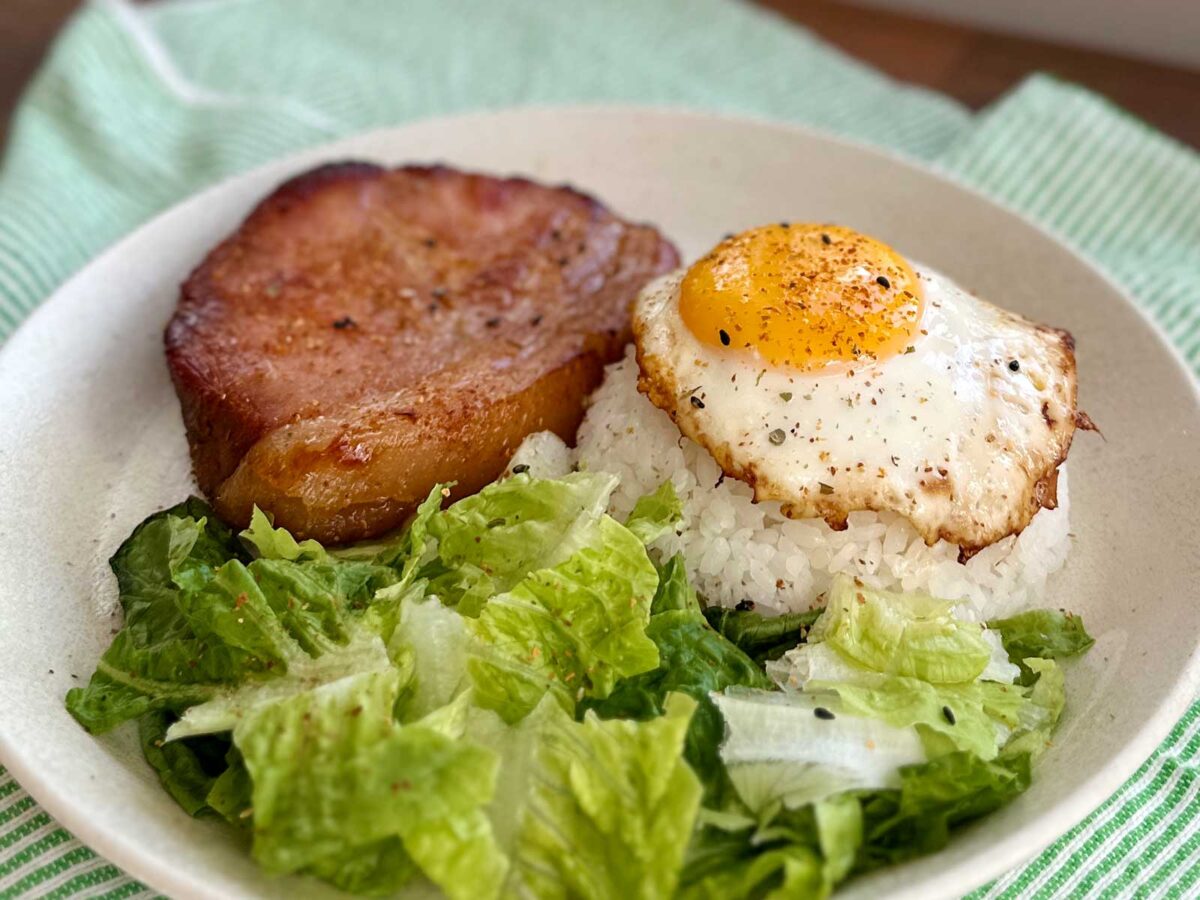 Ham steak, rice, egg and lettuce on plate