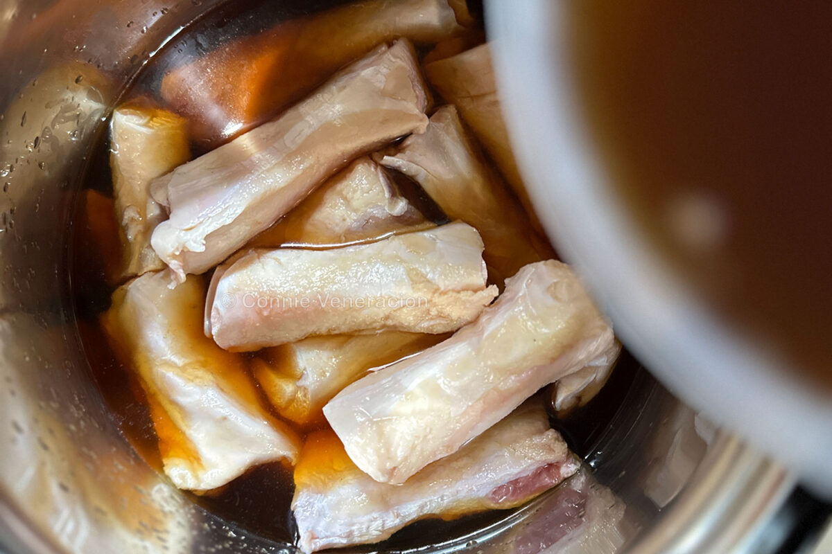 Pouring broth over beef tendon in slow cooker